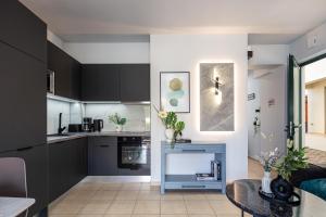 una cocina con armarios en blanco y negro y una mesa en Villa Lea, stylish, with common pool, en Chania