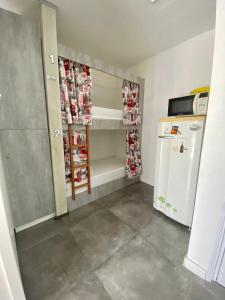 a small kitchen with a refrigerator and a refrigeratorvelt at Casa de Oliveira Hostel in Torres