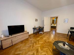 a living room with a flat screen tv on a wooden floor at Charmante Wohnung in Innenstadtlage in Graz