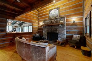 - un salon avec une cheminée en pierre et un canapé dans l'établissement Wagon Gap Trail: Lodge Lórien, à Canton