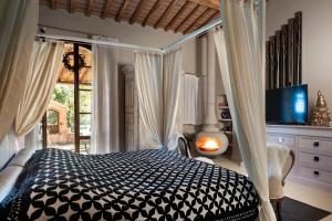 a bedroom with a bed with a black and white comforter at La Pieve di San Giovanni Luxury Retreat & Spa in Lustignano +156 photos