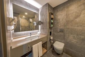 a bathroom with a toilet and a sink and a mirror at The X Belek in Belek