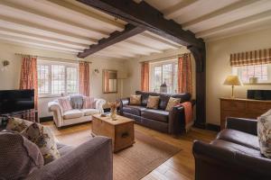 a living room with couches and a tv at Half Way House, Clappersgate, sleeps 8 in Ambleside