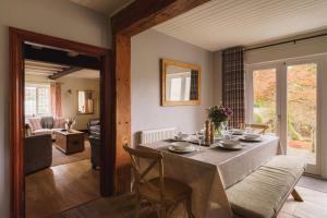 a dining room with a table and a living room at Half Way House, Clappersgate, sleeps 8 in Ambleside