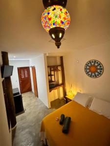 ein Schlafzimmer mit einem gelben Bett und einem farbenfrohen Kronleuchter in der Unterkunft Noronha Pura Vida in Fernando de Noronha