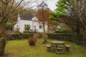 a picnic table in front of a white house at Half Way House, Clappersgate, sleeps 8 in Ambleside