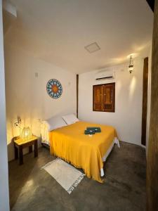 ein Schlafzimmer mit einem Bett mit einer gelben Decke in der Unterkunft Noronha Pura Vida in Fernando de Noronha