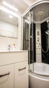 a white bathroom with a shower and a sink at Complex panoramic Mihai Bravu cu internet de mare viteza si parcare gratuita in Bucharest +12 photos