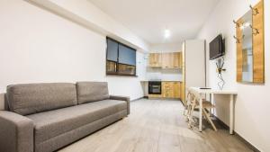 a living room with a couch and a table at Complex panoramic Mihai Bravu cu internet de mare viteza si parcare gratuita in Bucharest