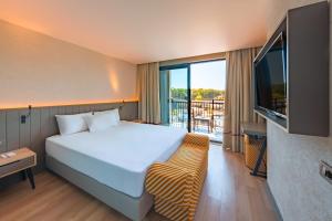 a hotel room with a bed and a flat screen tv at The X Belek in Belek +37 photos