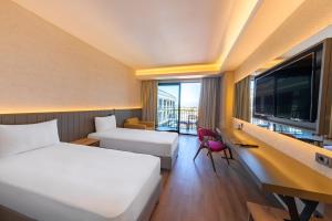 a hotel room with two beds and a desk with a computer at The X Belek in Belek