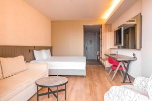 a hotel room with a bed and a couch at The X Belek in Belek