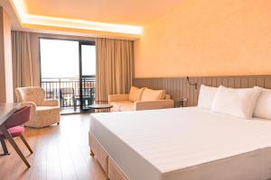 a hotel room with a large bed and a balcony at The X Belek in Belek