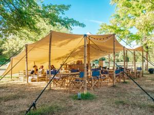 Sainte-Gemme-sur-LoireLodg'ing Nature Camp Anjou的田野上带桌椅的帐篷
