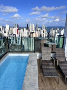 uma varanda com 2 cadeiras e vista para a cidade em Flat 26º andar com vista para o mar- Próximo ao shopping e à praia de Boa Viagem em Recife