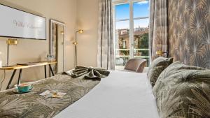a living room with a couch and a large window at Hotel Villa Victoria in Nice