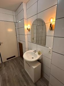 a bathroom with a sink and a mirror at Apartment Ruhepause II Ruhig & Komfortabel in Bad Bentheim