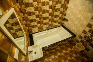 a bathroom with a tub and a sink and a mirror at Sri Balaji Villas Pondicherry with Car Parking in Pondicherry