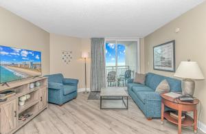 un salon avec un canapé bleu et une table dans l'établissement 1 Bedroom Oceanview Penthouse at Sandy Beach! 1905, à Myrtle Beach