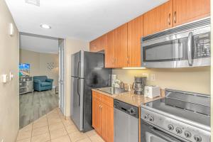 une cuisine avec un réfrigérateur en acier inoxydable et un évier dans l'établissement 1 Bedroom Oceanview Penthouse at Sandy Beach! 1905, à Myrtle Beach