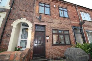 a brick building with a brown door and windows at Wellington House in Codnor