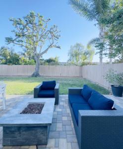 a patio with two blue couches and a table at Del Mar Coastal Haven in San Diego