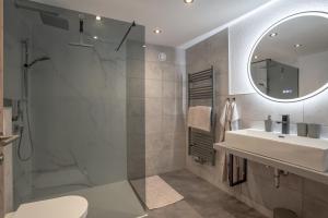 een badkamer met een wastafel, een douche en een spiegel bij Apart Wiesa in Kappl +23 foto's