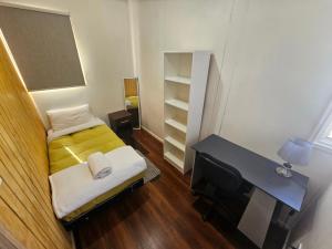 a small bedroom with a bed and a tv at Catema in Coihaique