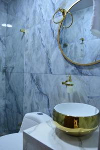 a bathroom with a gold sink on top of a toilet at Hotel Diamond Luxury Tunja in Tunja +57 photos