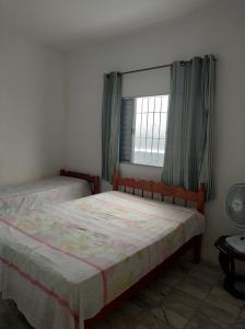 une chambre avec deux lits et une fenêtre dans l'établissement CANTINHO DA PRAIA, à Mongaguá