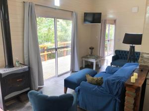a living room with blue chairs and a fireplace at Mercedes in Tigre