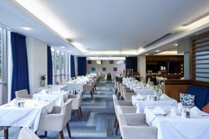 a dining room with white tables and chairs at Stamford Bridge Hotel London in London +16 photos