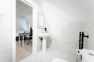 a white bathroom with a sink and a mirror at The Wood Green Star Self Contained Studios in London +62 photos