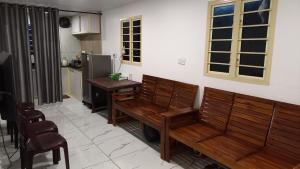 a kitchen with two wooden benches and a table at Pepper Mist Wayanad Homestay in Tindummal