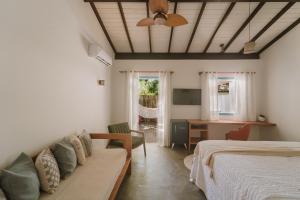 een slaapkamer met een bed, een bank en een bureau bij Aqualtune Pousada in Barra Grande