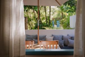 een patio met stoelen en een parasol bij Aqualtune Pousada in Barra Grande