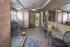 a room with a table and chairs and a sink at Polka Dot Airport Exec Suite in Kempton Park