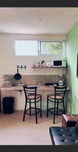 a kitchen with two chairs and a table with a microwave at Martha Cozy Apartments 2 in Valladolid +8 photos