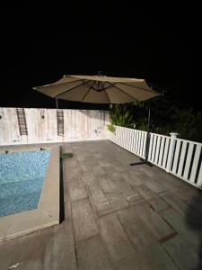 un ombrellone accanto alla piscina di notte di La Calma Private Pool a Jitra