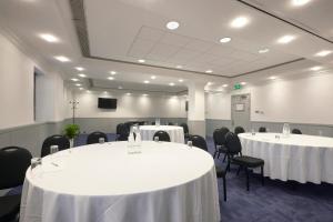 a room with two tables and chairs with white table cloth at Stamford Bridge Hotel London in London