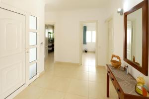 a hallway with white walls and a mirror and a bench at Casa de Suėños in Puerto del Carmen +20 photos
