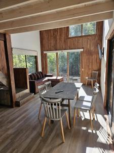 a living room with a table and chairs and a couch at Inspiramide Pucon in Pucón