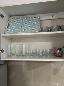 a kitchen shelf with bowls and glasses on it at Melvina in Pančevo +6 photos