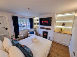 ein Schlafzimmer mit einem Bett und einem Kamin in der Unterkunft Stunning Cottage in Knutsford by City SuperHost in Knutsford