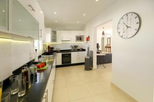 a kitchen with a large clock on the wall at Casa de Suėños in Puerto del Carmen