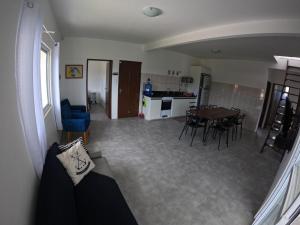 a living room and kitchen with a table and chairs at Casa Brisa Nordeste in Palhoça