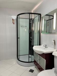 a bathroom with a glass shower and a sink at Hotel Bistrita in Bacău