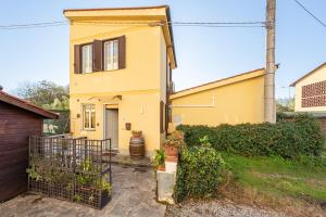 a yellow house with a fence in front of it at La Casina Gialla Independent House in Lucca
