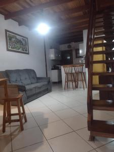 a living room with a blue couch and a kitchen at Chalé da Lu in Santo Antônio do Pinhal