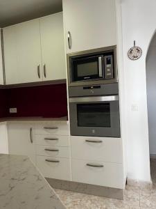 a kitchen with a microwave and a stove at La casa de Elisabeth in Nerja